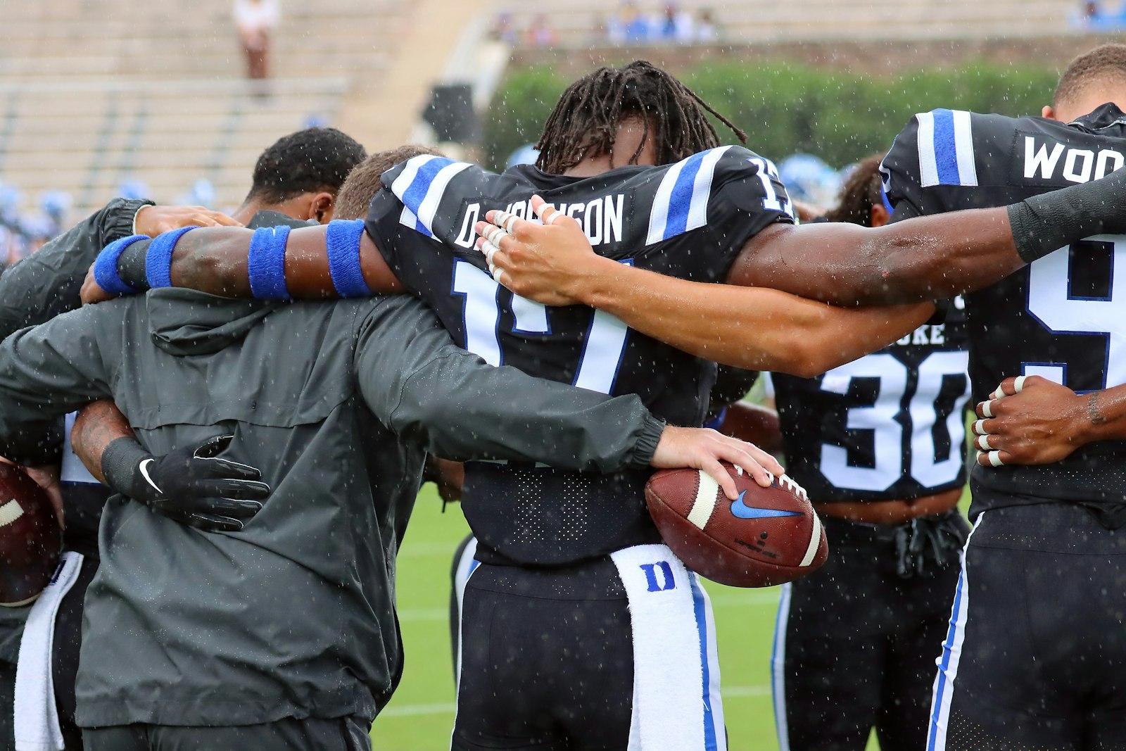 Football team huddled together on the field before a play